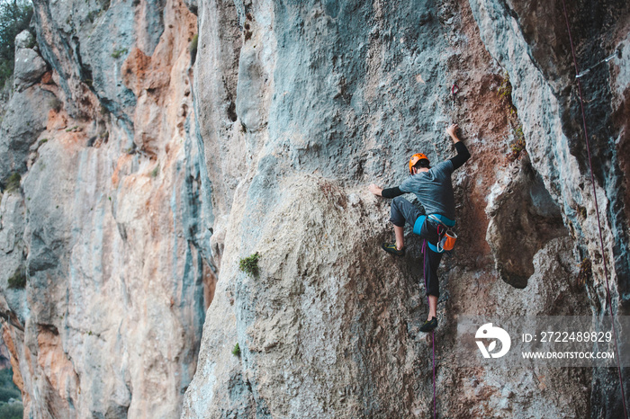 A man in helmet climbs the rock.