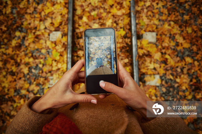 Woman making photo of leg on mobile