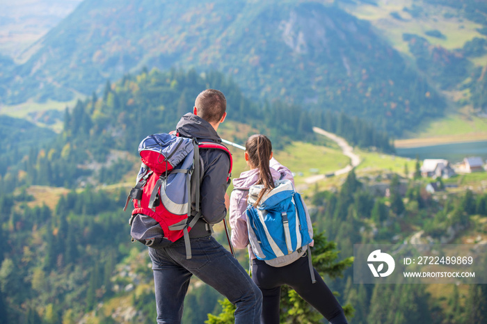 couple hiking in the mountain and enjoying view on the lake