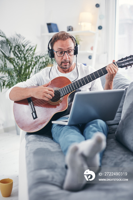 Man playing acoustic guitar in the living room.