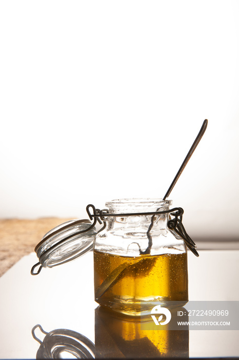 agave syrup in glass jar with spoon inside. White background