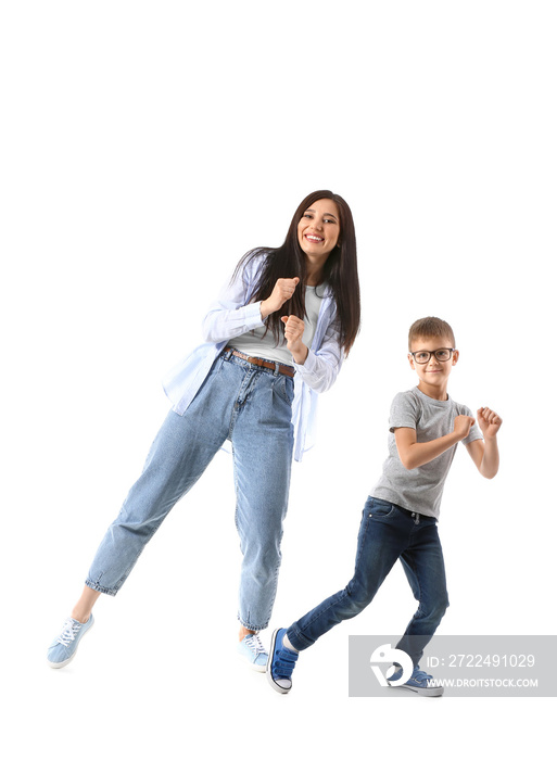 Dancing young woman and her little son on white background