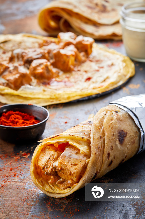 Paneer Makhani paratha roll kathi shawarma wrap with dipping sauce isolated on background side view of indian fastfood