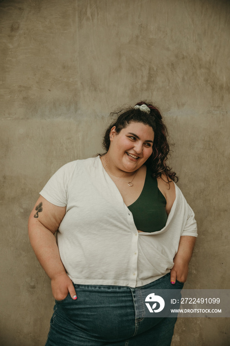 plus size woman smiles in front of textured background