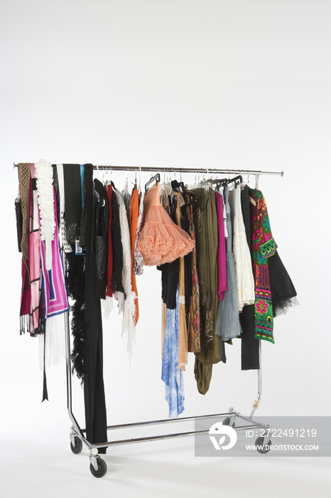 Collection of fashion clothes hanging on clothes rail isolated over white background