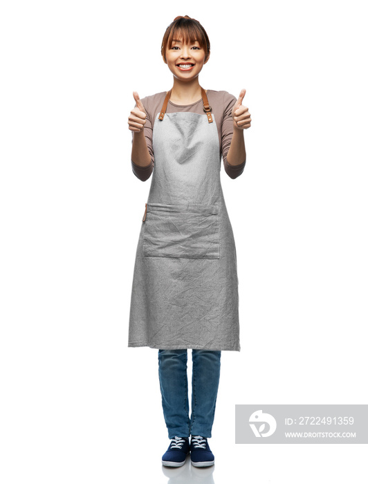 cooking, culinary and people concept - happy smiling woman in apron showing thumbs up over white background