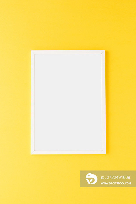 Empty picture frame on yellow wall. Mockup with copyspace