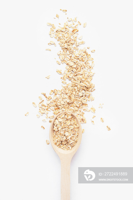 large raw oatmeal in a wooden spoon on a light gray background