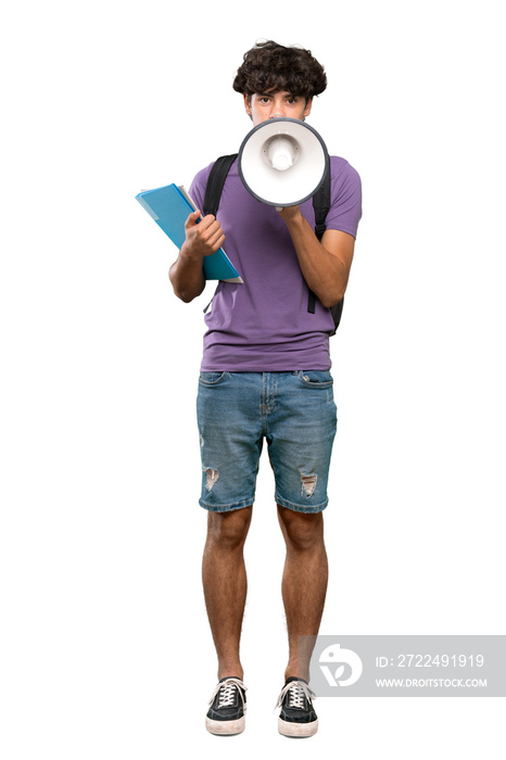 A full-length shot of a Young student man shouting through a megaphone over isolated white background