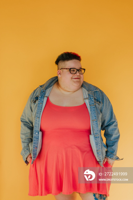 portrait of a plus size person looking to the side on yellow background