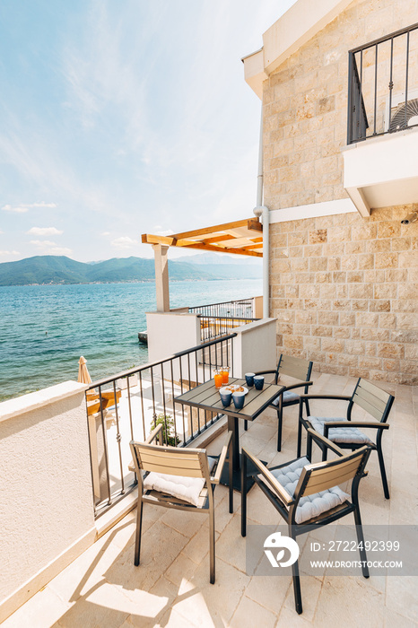 Croissants and freshly squeezed juice, garden furniture on the balcony overlooking the sea.