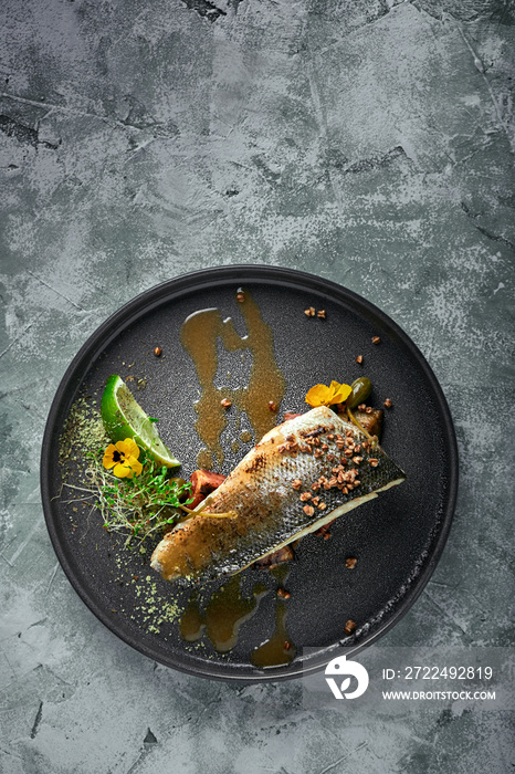 Grilled seabass with eggplant and lime. Horizontal top view, top shot. Copy space, gray concrete marble background, soft light. Food Fashion Photo.