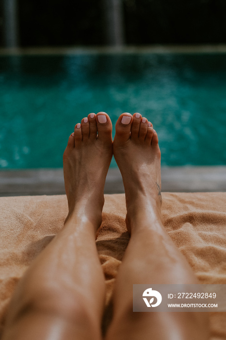 Beautiful female pedicure on the background of the pool