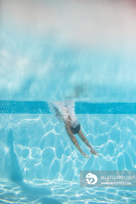 Young woman in a swimming pool performing some synchronized swimming drills