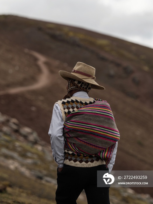 Man in traditional andean indigenous clothes at colorful Palccoyo rainbow mountain Palcoyo Cuzco Peru South America