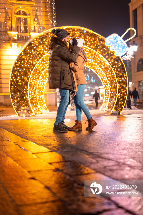 Couple hugging in city square for Christmas