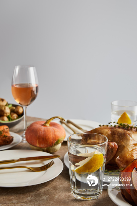 whole pumpkin near grilled turkey, and glasses with rose wine isolated on grey