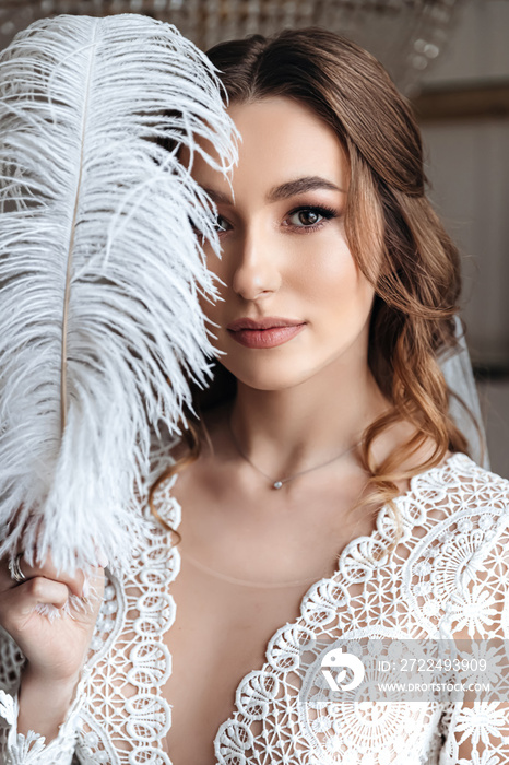 Wedding portrait of the bride with a large decorative feather.