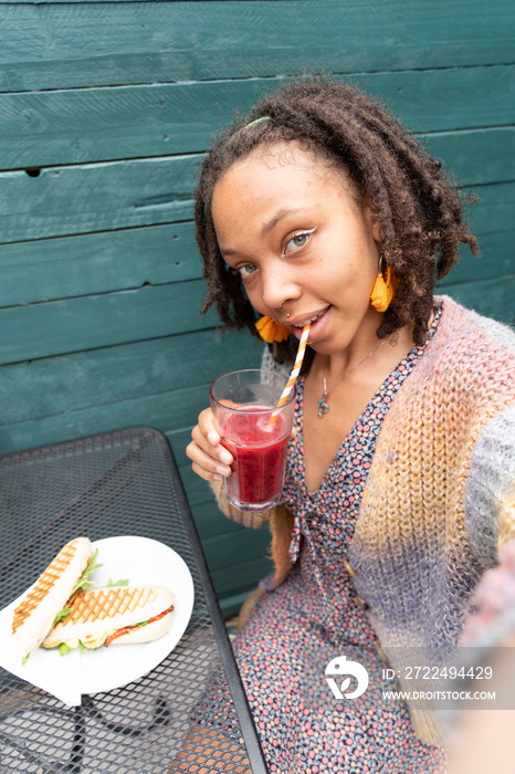 Portrait of smiling woman taking selfie during lunch break in garden