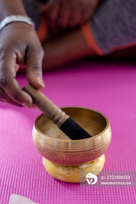 Close-up of woman’s hand using singing bowl in yoga studio