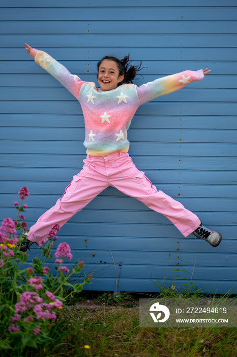 Portrait of smiling girl (8-9) jumping outdoors