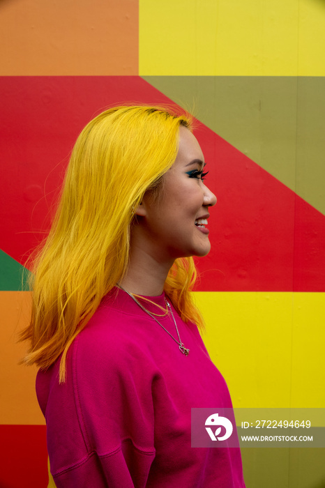 Profile view of smiling young woman with yellow hair