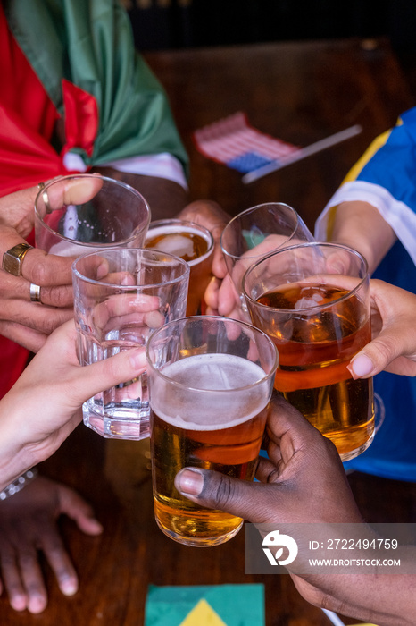 Friends dressed in national flags for world cup competition drinking beer