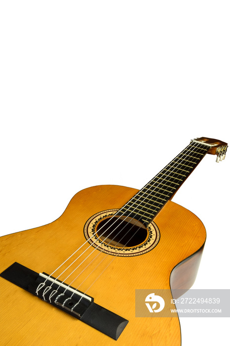 Acoustic wooden guitar of brown color lies on its side on a white background