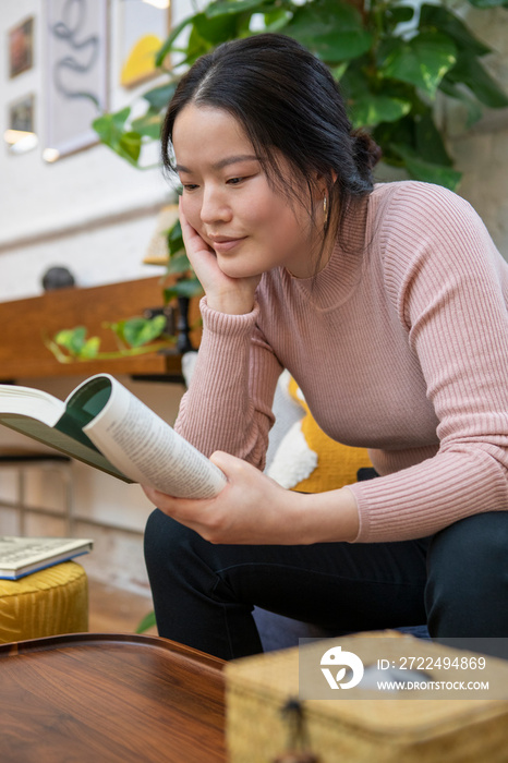 Woman reading book at home