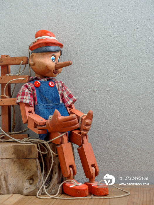 Pinocchio puppet made from wood.Sitting on wood box