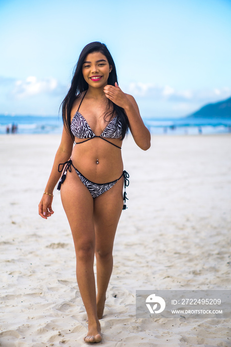 young beautiful and happy Asian Indonesian woman in bikini enjoying holidays at tropical beach in Bali enjoying holidays and travel