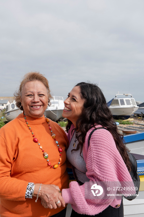 Portrait of smiling mother standing with daughter in harbor