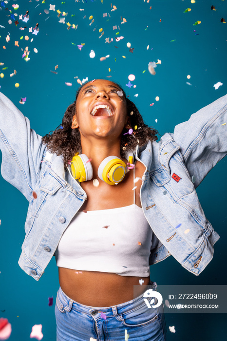 Young woman dancing while spreading confetti