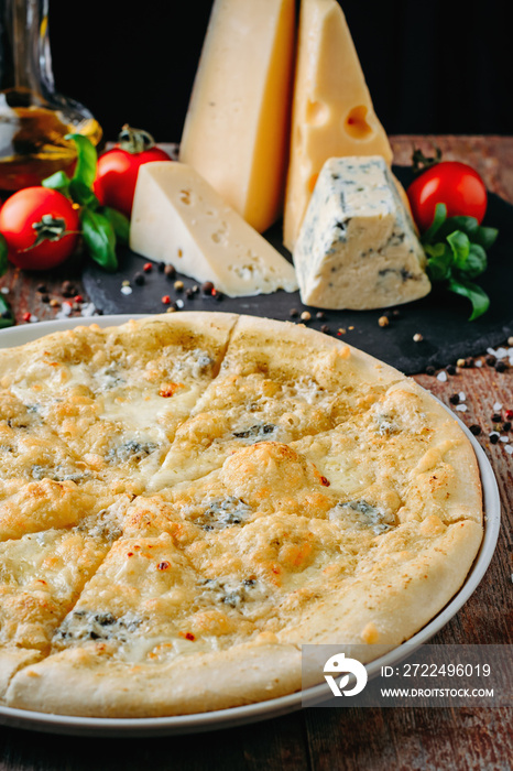 Pizza four cheese and ingredients on a wooden table