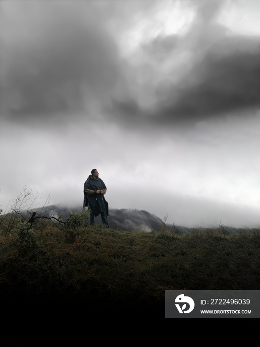 Wayfarer traveling across the mountains on a dark day