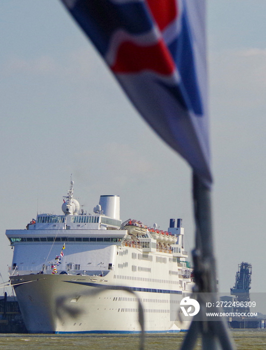 Classic British cruiseship cruise ship liner docked in Tilbury, London UK on River Thames seen from excursion boat with flying flag Union Jack