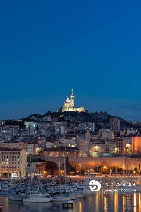 The Old Port and Basilica of Notre Dame de la Garde at dusk in Marseille, France