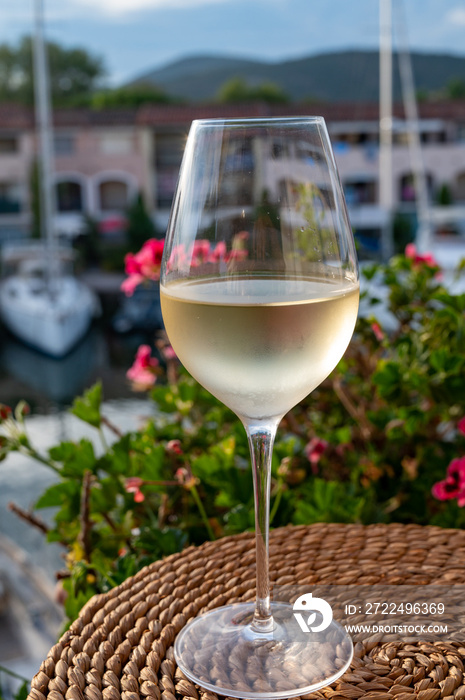 Tasting of local white wine in summer with sail boats haven of Port Grimaud on background, Provence, France