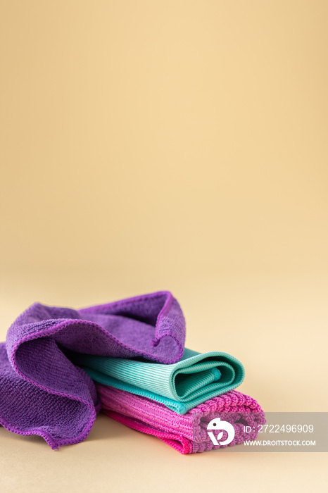 Multicolored microfiber cloths for washing on a neutral beige background, cleaning concept