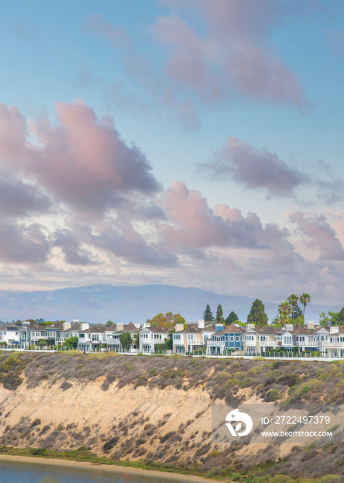 Vertical Puffy clouds at sunset Newport Beach neigborhood near the slope of the waterfront at Ca