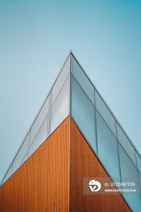 Top corner of a sharp modern design glass and wood building