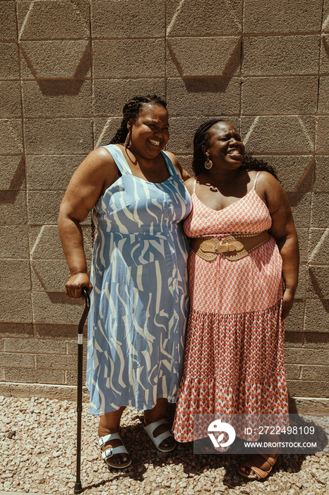 2 plus size African American women embrace and talk and laugh