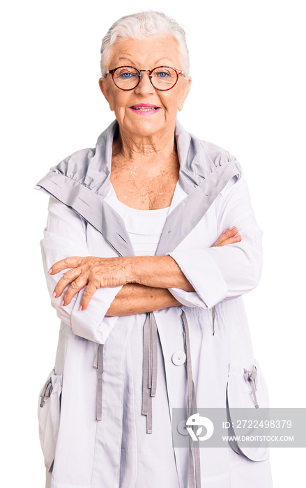 Senior beautiful woman with blue eyes and grey hair wearing casual clothes and glasses happy face smiling with crossed arms looking at the camera. positive person.