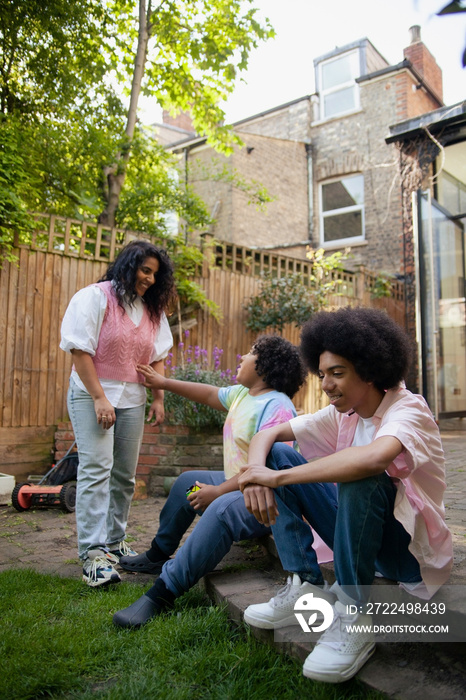 Mid-sized mother having fun with her sons in the garden