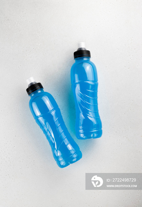 Isotonic energy blue sports drink in plastic bottles on the white background, top view