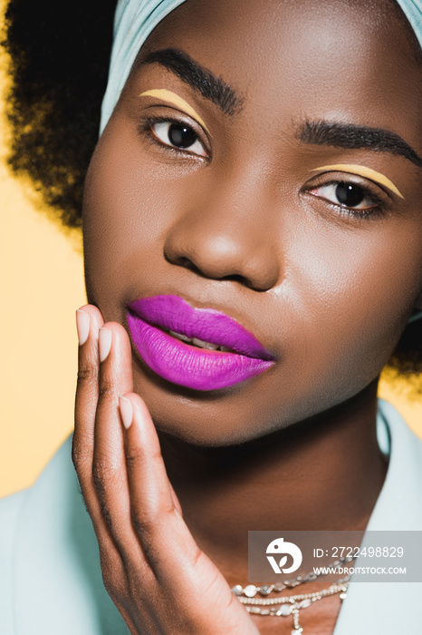 african american woman with purple lips isolated on yellow