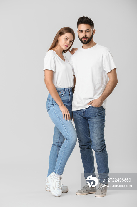 Stylish young couple in jeans on white background