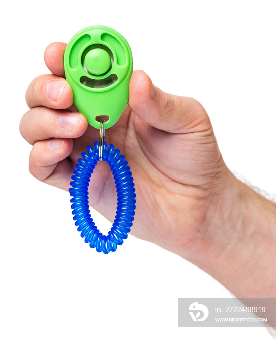 Man hand holding dog clicker - positive reinforcement training tool for dogs, isolated on white background. Clicker used for animal training.