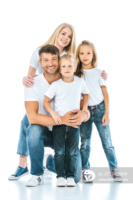 positive family smiling while looking at camera on white