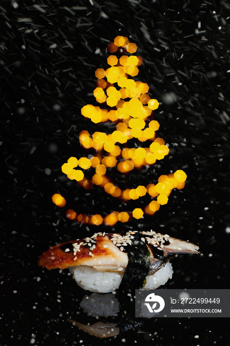 Sushi rolls New Year. Christmas background. Idea for postcard, menu, advertising. Roll on dark background where a fir tree with lights is shining. Decoration for menu